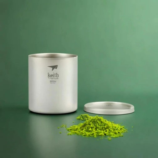 Taza de titanio doble pared y tapa 220 ml Keith en encimera verde con té matcha