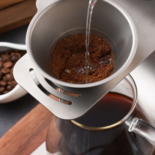 Detalle de la Cafetera de titanio y borosilicato Pour Over kit Keith haciendo café por goteo