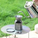 Una persona vierte agua caliente para hacer café al aire libre sobre el mini kit cafetera tetera Keith