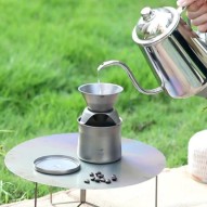 Una persona vierte agua caliente para hacer café al aire libre sobre el mini kit cafetera tetera Keith