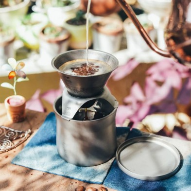 Una tetera vierte agua sobre los posos de café de la cafetera de viaje Keith