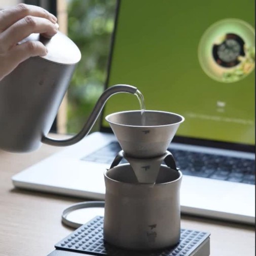 haciendo café con el kit de cafetera Keith, con un ordenador portátil de fondo.
