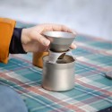 Una mano sirve café sobre la taza del kit de cafetera keith