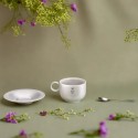 Taza café titanio platillo y cuchara 150 ml Keith en un ambiente natural con flores