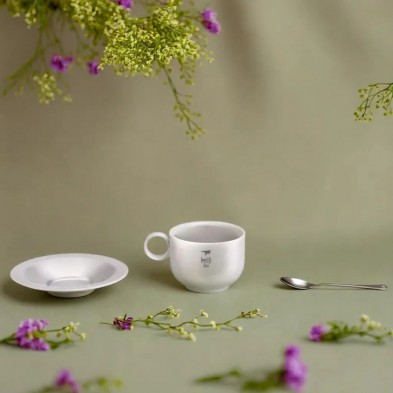 Taza café titanio platillo y cuchara 150 ml Keith en un ambiente natural con flores