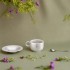 Taza café titanio platillo y cuchara 150 ml Keith en un ambiente natural con flores