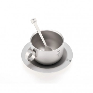 Taza plateada con asa, cuchara en el interior, sobre platillo a juego, todo con diseño minimalista hecho de titanio