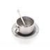 Taza plateada con asa, cuchara en el interior, sobre platillo a juego, todo con diseño minimalista hecho de titanio