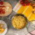 La olla ALLROUND llena de espaguetis cocidos rodeada de ingredientes y utensilios de cocina sobre una encimera. La olla ALLROUND llena de espaguetis cocidos rodeada de ingredientes y utensilios de cocina sobre una encimera.
