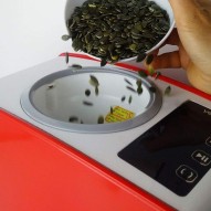 Echando semillas de calabaza dentro del Extractor de aceite vegetal Yoda