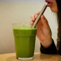 Una chica bebiendo un batido verde con la Pajita titanio ancha Keith