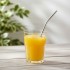 Pajita titanio curvada Keith en un vaso con zumo de naranja Pajita titanio curvada Keith en un vaso con zumo de naranja