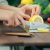 Cuchillo de titanio pequeño Keith con funda de cuero sobre la mesa y cortando con él una rodaja de limón
