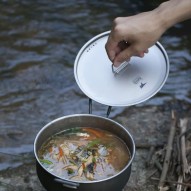 Cocinando un guiso vegetal cerca del río con la Olla baja de titanio 1800 ml Keith con tapa puesta