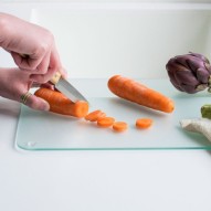 cortando zanahorias y hortalizas en la Tabla de cortar de vidrio templado mediana Pebbly