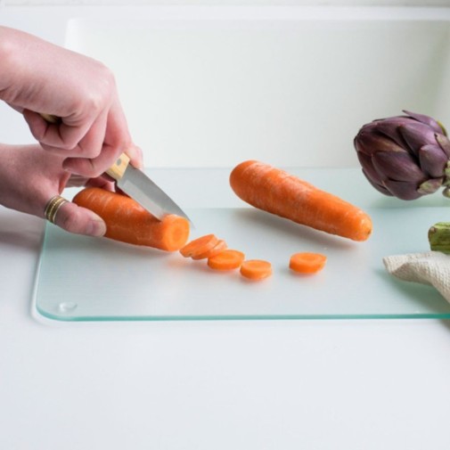 cortando zanahorias y hortalizas en la Tabla de cortar de vidrio templado mediana Pebbly