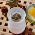 Quemador Lucerna Nature's Design sobre fondo blanco recipiente lleno de hierbas aromáticas