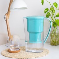 La jarra de agua alcalina Jarra con filtro Zeolita Clinoptilolita Alkanatur en la mesita de noche