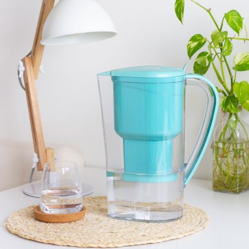La jarra de agua alcalina Jarra con filtro Zeolita Clinoptilolita Alkanatur en la mesita de noche