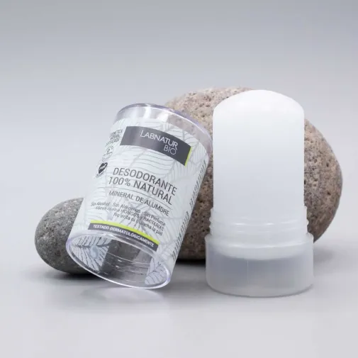Desodorante natural de alumbre en stick 120 g de Laboratorio Sys abierto sin su tapa apoyado en una piedra