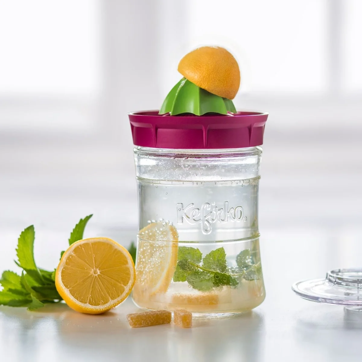 Tarro Kefirko con kéfir de agua, limón y menta y el exprimidor encajado en la tapa